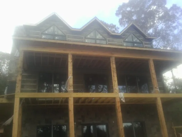 Dormers and porch framing on a large log home under construction in Urbana